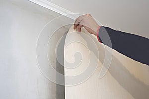 Worker glues wallpaper on the wall. Home repair concept