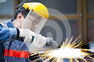 Worker with grinder machine cutting metal