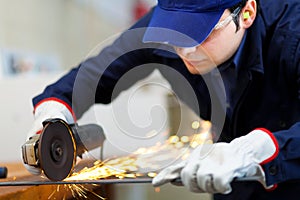 Worker grinding a metal plate