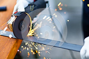 Worker grinding a metal plate photo