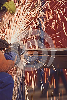 Worker grinding a metal plate