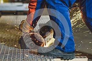 Worker grinding a metal plate