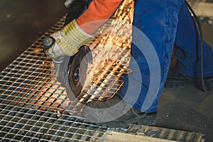 Worker grinding a metal plate