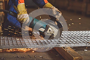Worker grinding a metal plate