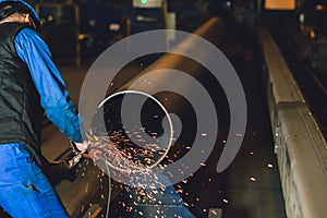 Worker grinding a metal plate
