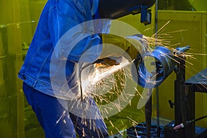 The worker grinding the steel pipe after welding