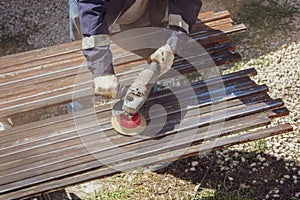 A worker grinds a rusty metal pipe
