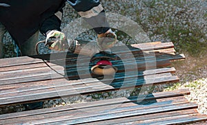 A worker grinds a rusty metal pipe