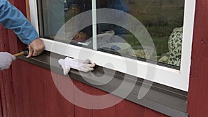 Worker with hammer fixing new window sill sheet metal