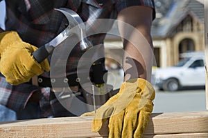 Worker Hammering Nail At Site