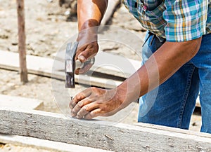 Worker hammering nail into wood