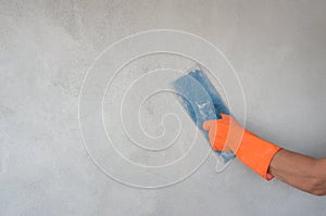 worker hand with glove holding trowel is plastering cement wall