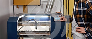 Worker with hand on hip pressing on CNC machine