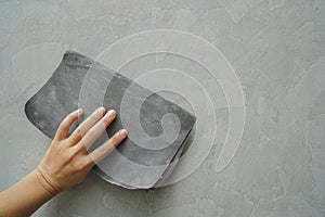 Worker hand use sandpaper for smooth cement wall texture