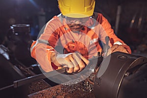 Worker handles metal at lathe Turner measures the dimensions of the metal workpiece with a caliper in uniform with safety. Work on