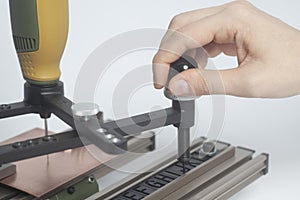 Worker hands on Engraving device pantograph with CNC engraver with letterpress alphabet
