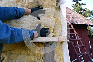 Worker hands on house insulatiom material rockwool