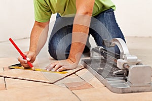 Worker hands laying ceramic floor tiles