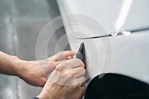 Worker hands polishing exterior surface of auto body panel