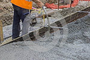 Worker hands using concrete vibrator photo