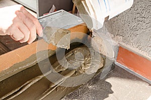 Worker hands using spatula and plastering ceiling with putty. Mesh on split. Closeup