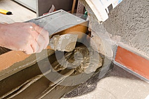 Worker hands using spatula and plastering ceiling with putty. Mesh on split. Closeup