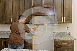 Worker hanging a level in preparation for the leveling of a new kitchen cabinet furniture set that will be installed