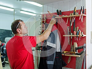 The worker hangs his jacket in his working room