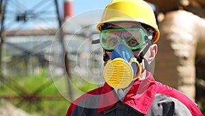 Worker in hard hat, goggles and respirator at power station