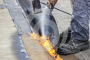 Worker heating and melting bitumen felt 3 photo