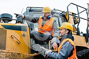 Worker with heavy excavation machinery in mining operation