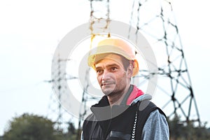 Worker in a helmet against the background of a substation