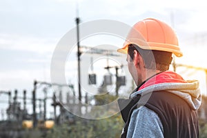 Worker in a helmet against the background of a substation