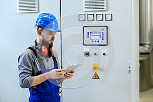 Worker with helmet ,ear protector and tablet computer