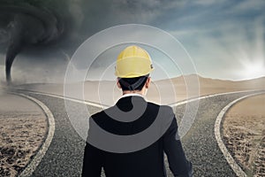 Worker with helmet looking at two roads