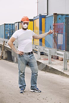 Worker in a helmet and a protective mask stands at the container photo