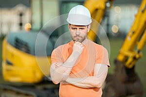 Worker in helmet on site construction. Excavator bulldozer male worker. Construction driver worker with excavator on the