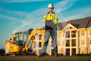 Worker in helmet on site construction. Excavator bulldozer male worker. Construction driver worker with excavator on the