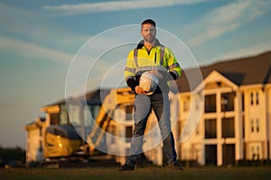 Worker in helmet on site construction. Excavator bulldozer male worker. Construction driver worker with excavator on the