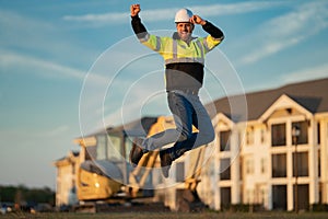 Worker in helmet on site construction. Excavator bulldozer male worker. Construction driver worker with excavator on the