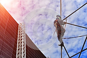 Worker on high wear safety harness on scaffolding.
