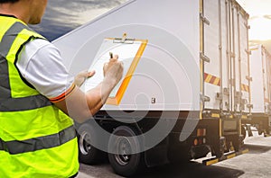 Worker holding clipboard his inspecting control load cargo freight with container trailer truck.