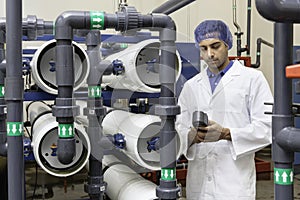 Worker holding an equipment in bottling plant