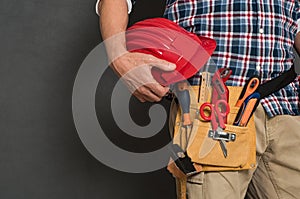 Worker holding hardhat and toolkit