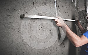 Worker holding level tool. Plastering wall. Construction work