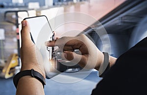 Worker Holding A Smartphone is Contacting with A Customer to The Shipment. Freight Truck Transport. Road Delivery with Trucks.