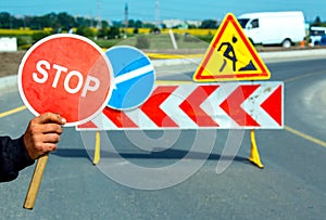 Worker holding a stop sign during road construction.