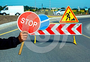 Worker holding a stop sign during road construction.