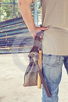 Worker holding tool bag in construction site