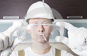 Worker holding transparent safety glasses